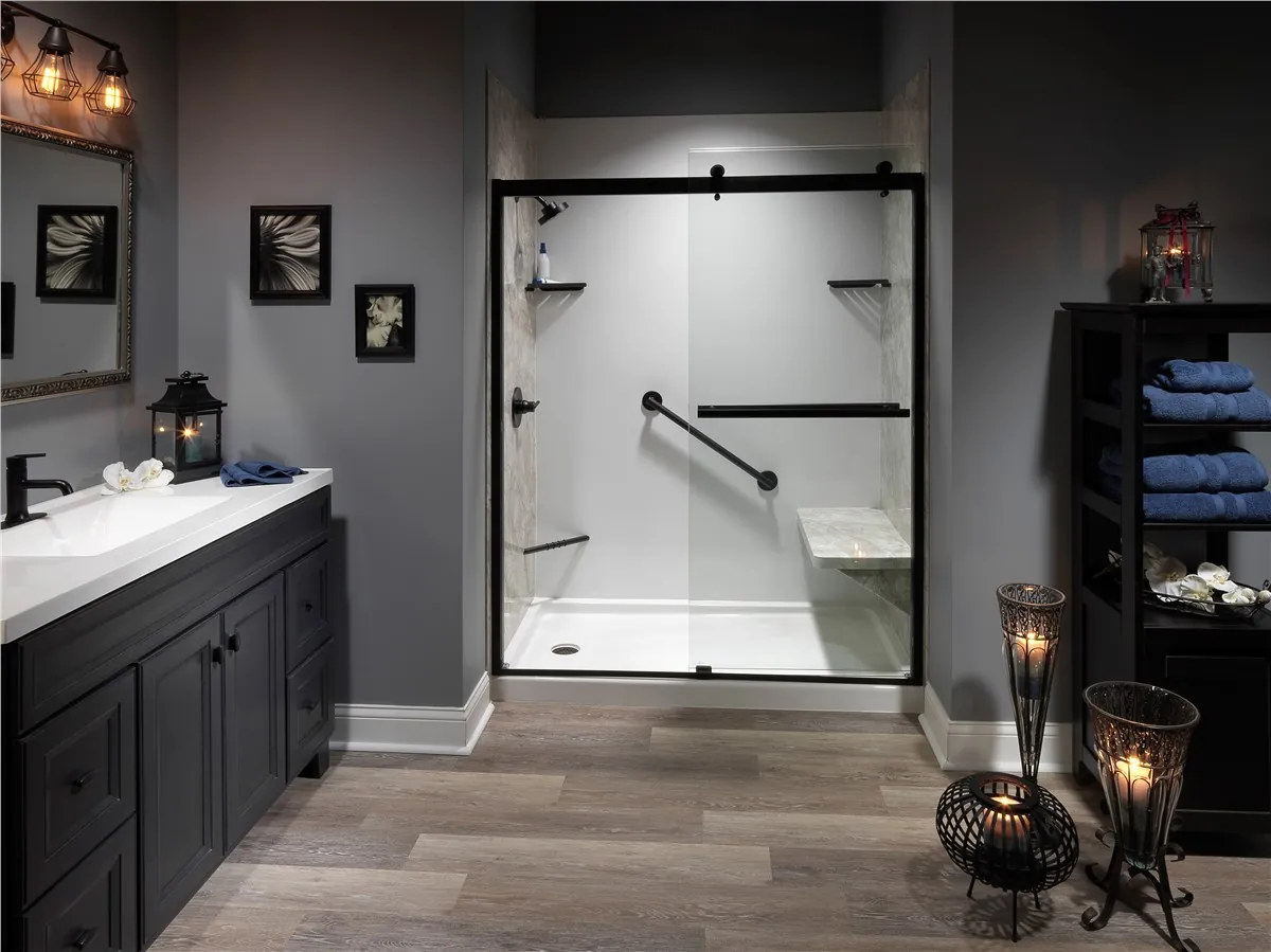 Shower with a black-framed sliding glass door, white and stone-look wall panels, a grab bar, shelves and a built-in seat